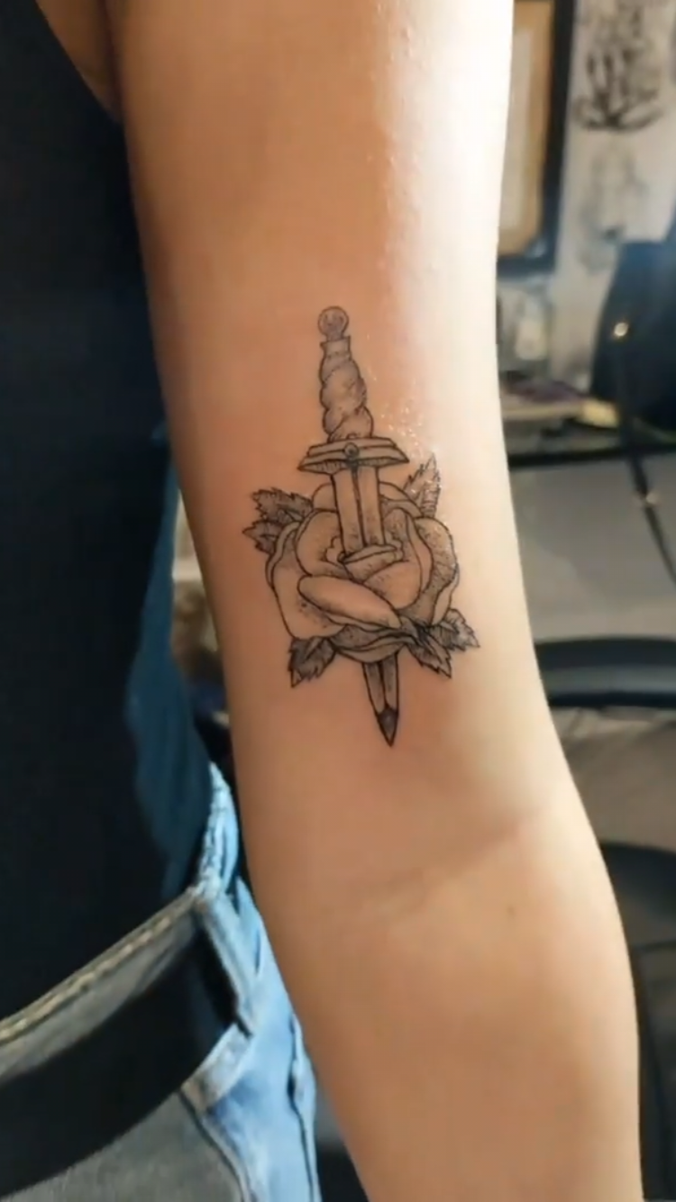 Traditional dagger and rose arm tattoo