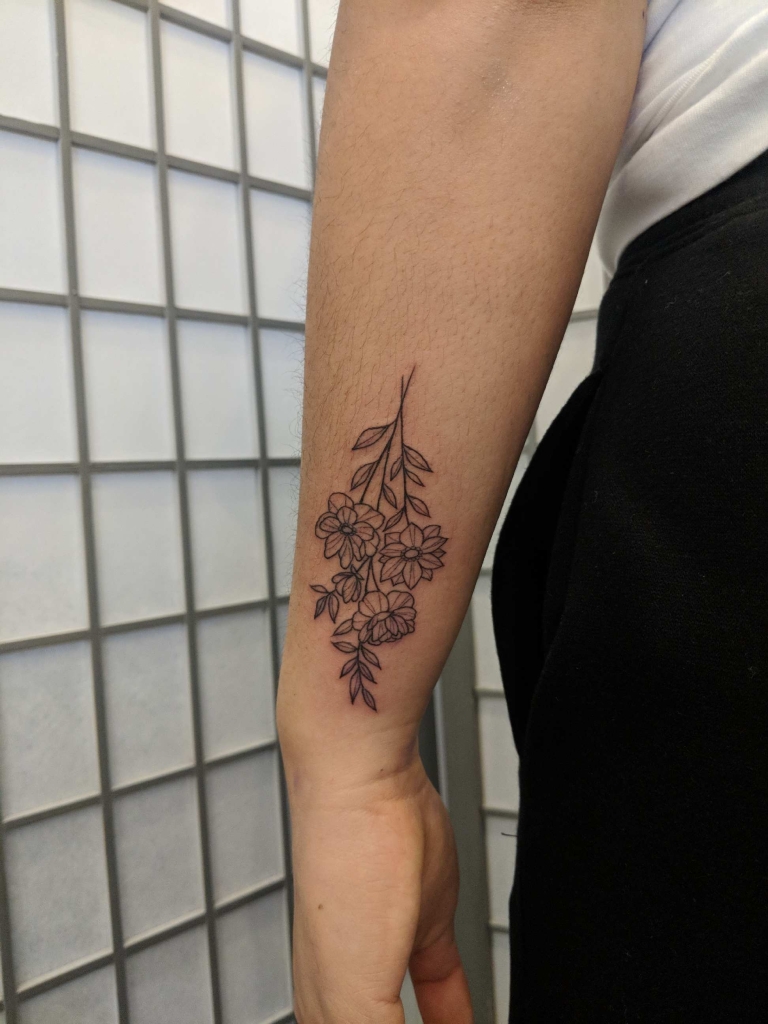 Clean floral linework tattoo on forearm